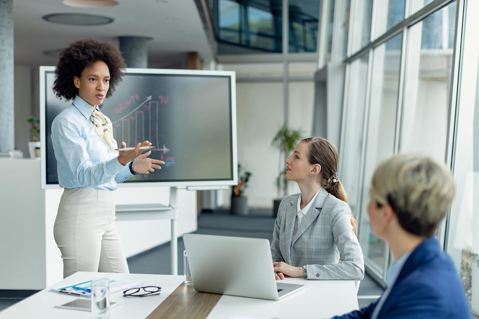 Professionista che presenta un argomento a colleghe in ufficio